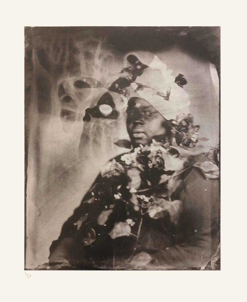 Alt-text: Khadija Saye, facing the camera, with the blurry outlines of plastic flowers found her neck